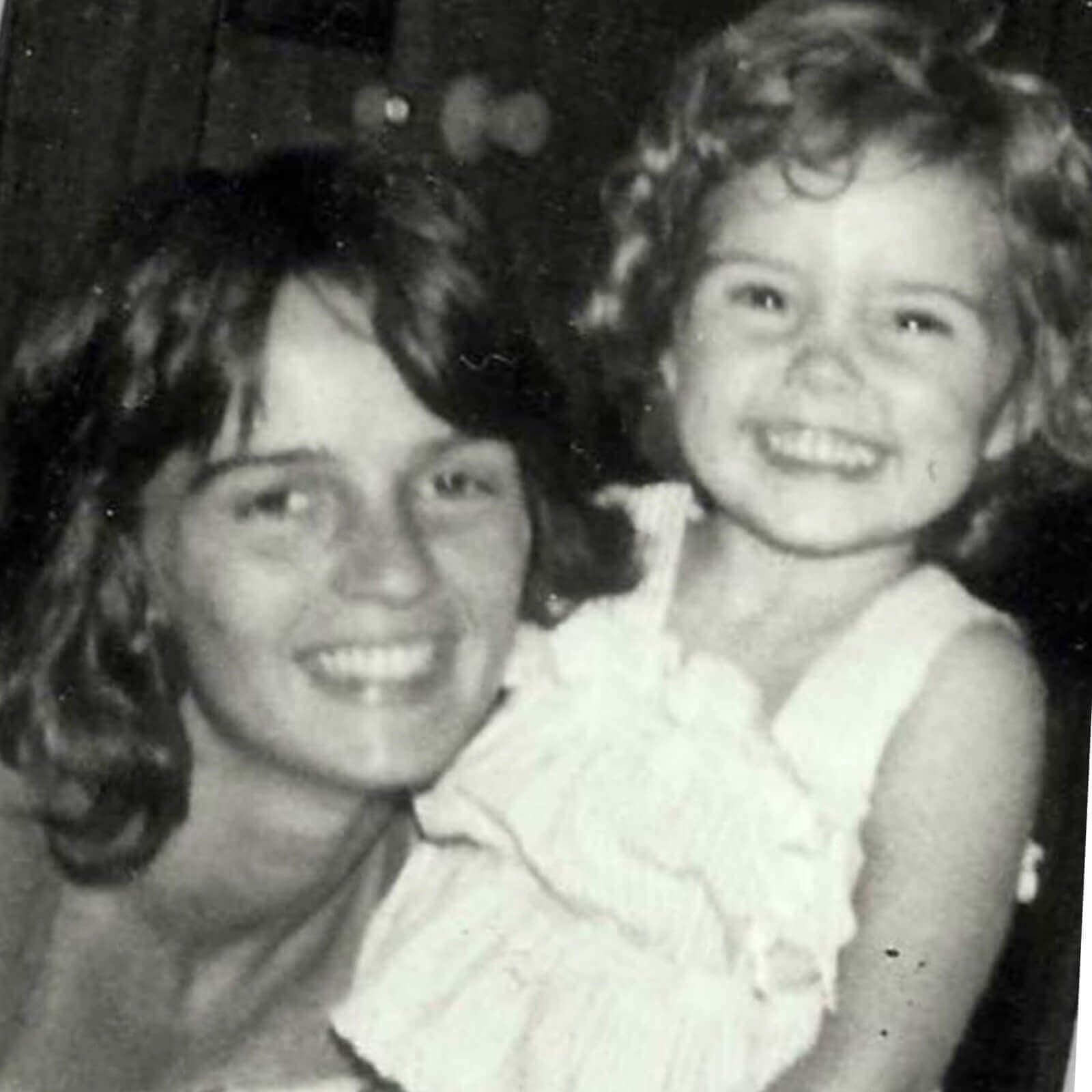 Smiling woman and child in black and white photo, capturing a joyful moment, only available at Potency No. 710.