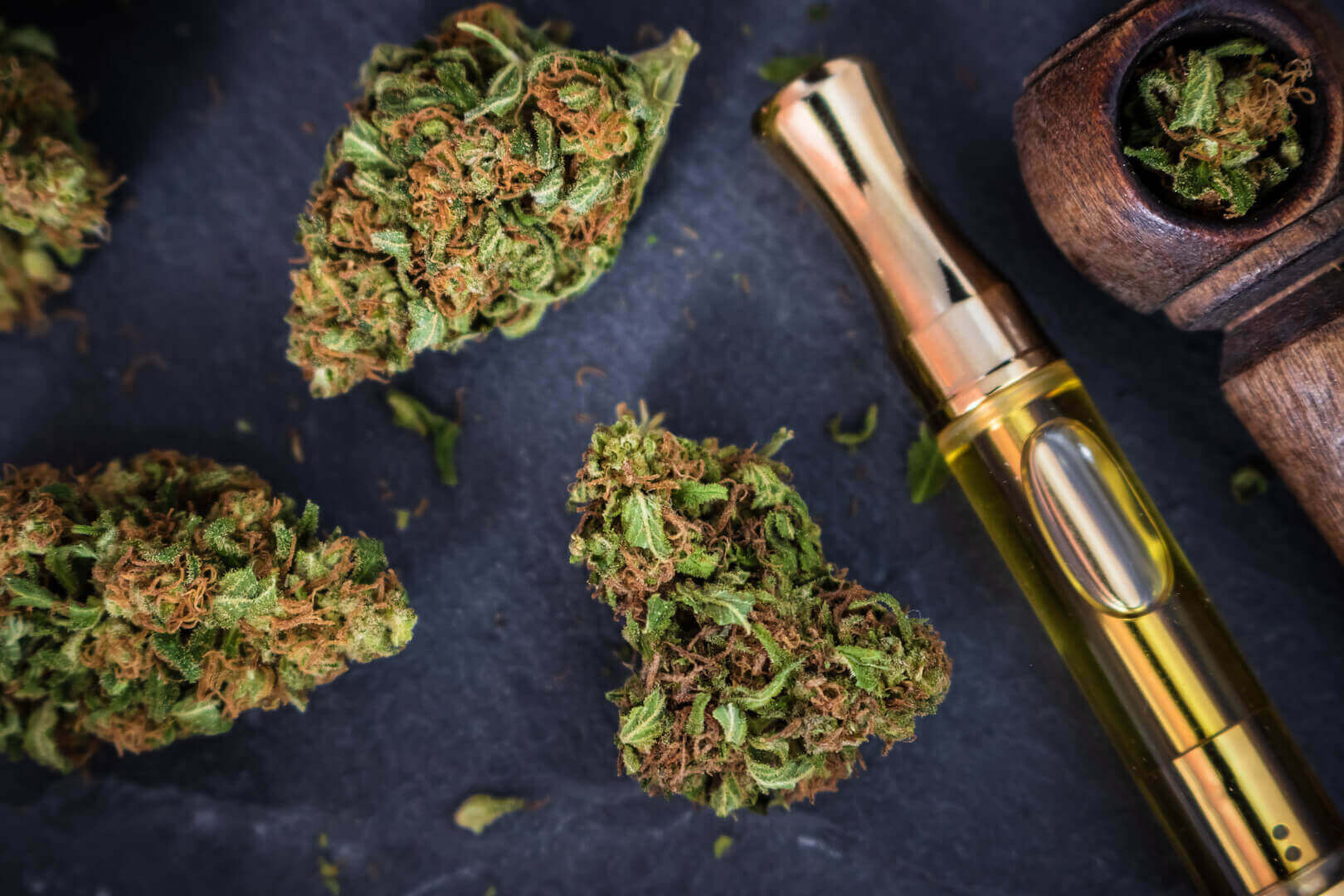 Cannabis buds and vape pen on slate background, premium quality from Potency No. 710.