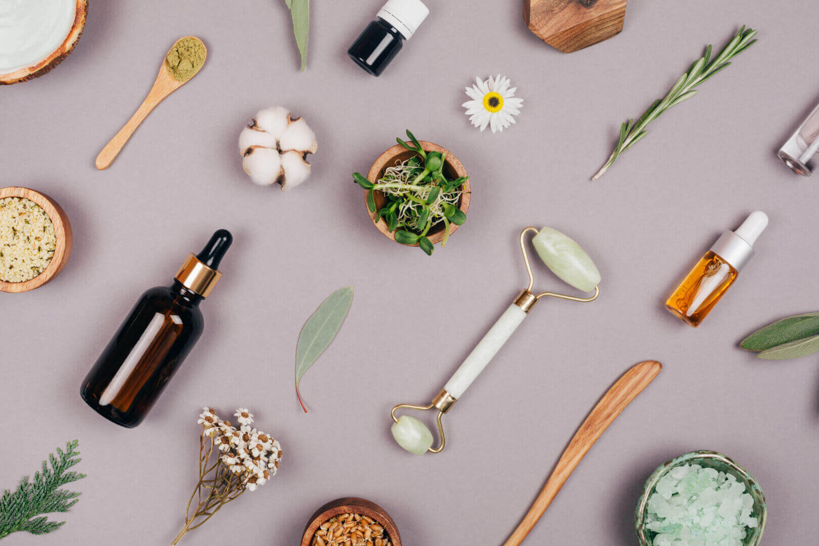 Natural skincare products and tools flat lay from Potency No. 710, featuring essential oils and botanicals for wellness.